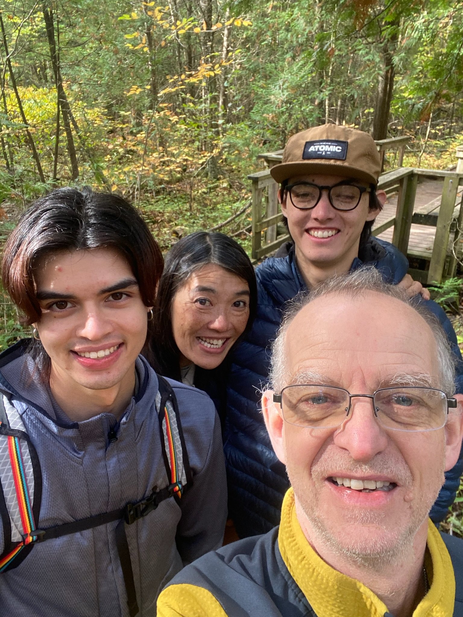 Matt and his family on a wooden boardwalk in autumn woodland at Crawford Lake Conservation Area, Ontario