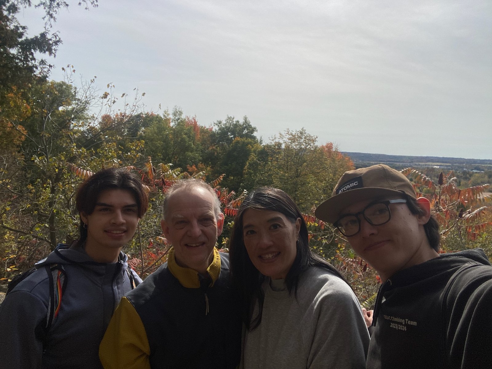The family at a lookout near Rattlesnake Point, with red sumac and a wide view over the Ontario countryside behind them